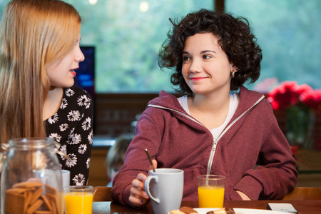 Two teen girl friends having breakfast together at home.の写真素材