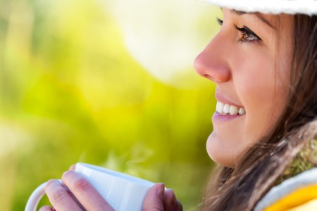 Extreme close up of young girl drinking coffee outdoors の写真素材