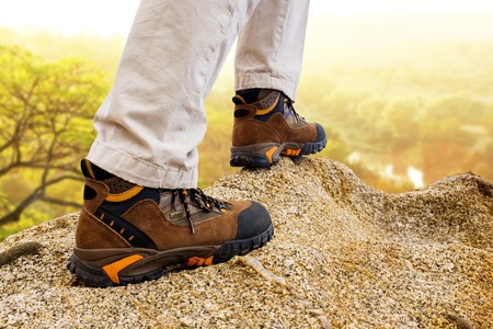 Macro close up of female hiker boots on rocks.の写真素材
