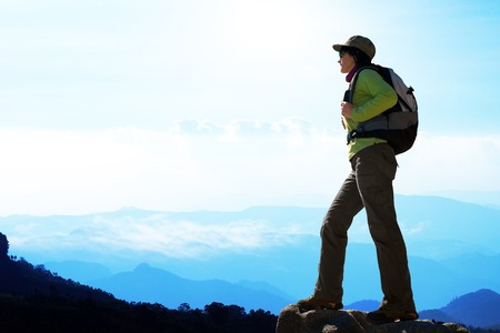 Silhouette of female hiker against blue mountain scape.の写真素材