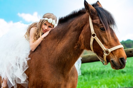 Portrait of cute girl relaxing on horseback outdoors.の写真素材