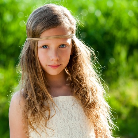 Close up portrait of attractive young girl wearing ribbon headband outdoors.の写真素材