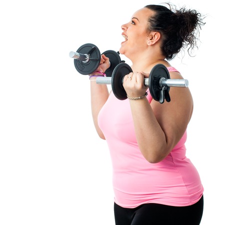 Close up side view of obese girl doing workout with weights.の写真素材