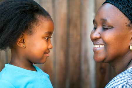 Close up portrait of African mother and daughter looking at each other.の写真素材