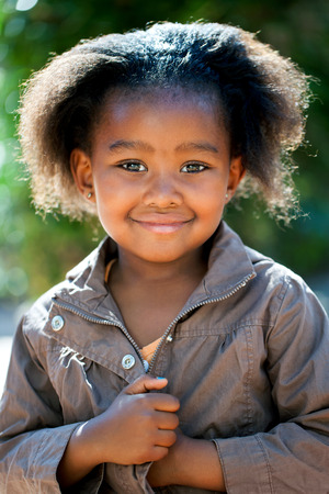 Outdoor portrait of cute African girl wearing brown jacket.の写真素材