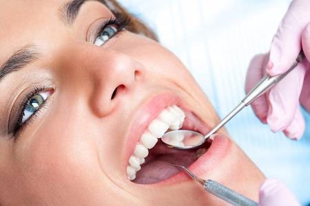 Extreme close up of beautiful young girl having dental check up.の写真素材