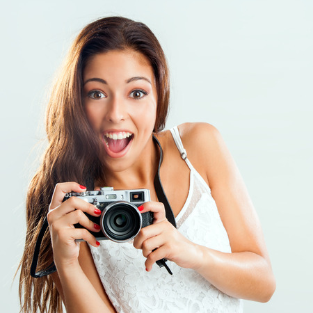 Close up portrait of happy young girl holding retro camera.の写真素材