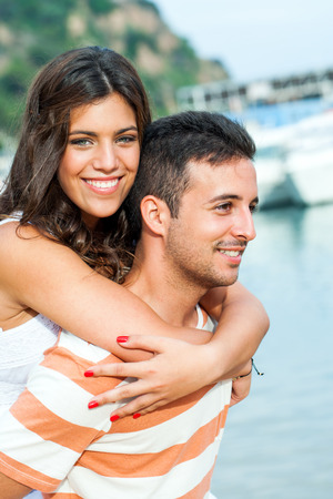 Outdoor portrait of cute boy piggybacking girlfriend.の写真素材