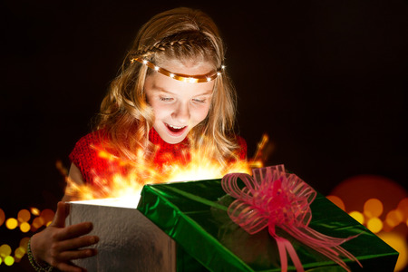 Close up portrait of Emotional girl opening Christmas present.の写真素材