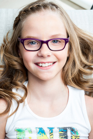 Close up portrait of smiling girl laying in dental clinic ready for check up.の写真素材