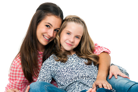 Close up Portrait of cute teen girl with younger sister.Isolated on white background.の写真素材