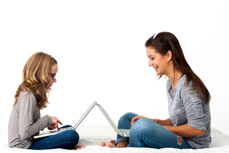 Portrait of Young Girls working together on laptops.Isolated on white background.の写真素材