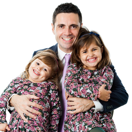 Close up portrait of young businessman in suit holding his two little daughters.Isolated on white background.の写真素材