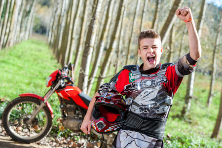 Close up portrait of handsome teen Motocross champion with winning attitude outdoors.の写真素材