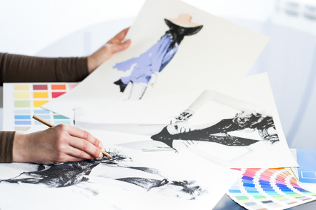 Extreme close up of fashion designer at work with fashion sketches and color charts.の写真素材