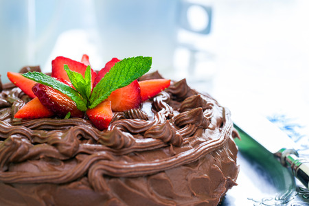 Macro close up of appetizing brown chocolate cake with decorative strawberries.の写真素材