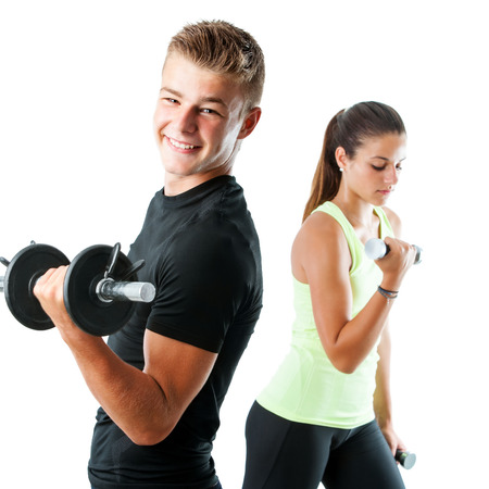 Close up portrait of handsome teen boy working out with weights.Out of focus girl working out in background.Isolated on white.の写真素材