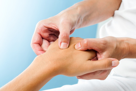 Macro close up of Therapist doing massage on female hand.Osteopath applying pressure on hand.の写真素材