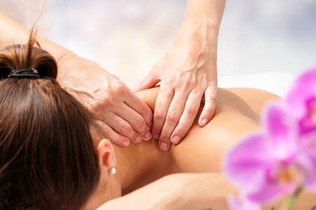 Macro close up of hands massaging female neck and shoulders.の写真素材