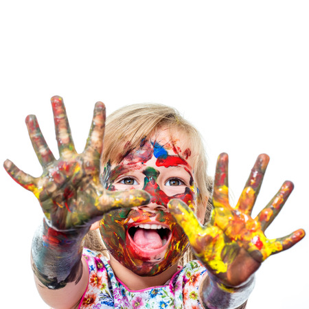 Close up portrait of shouting Little Girl messed with color paint.Infant showing hands covered with paint. Isolated on white background.の写真素材