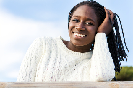 Close up outdoor portrait of attractive african teen girl with charming smile and braided hairstyle.の写真素材