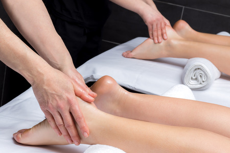 Close up of physiotherapists doing reflexology massage on couple.の写真素材
