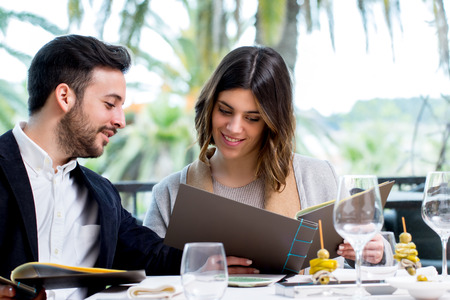 Close up portrait of young couple looking at restaurant menu in Hotel.の写真素材