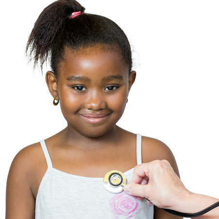 Close up portrait of cute little african girl having heartbeat taken.Hand positioning stethoscope against chest.Isolated on white background.の写真素材