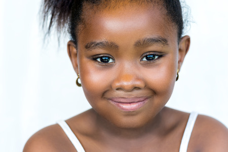 Close up face shot of cute little african girl with ponytail.Isolated on white background.の写真素材