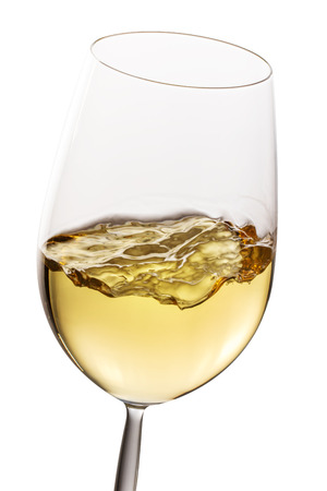 Extreme close up of crystal glass with white wine. Motion effect of wine isolated on white background.の写真素材