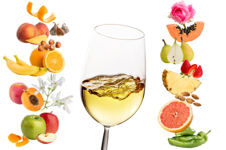 Macro close up of white wine glass surrounded by multiple fruits and flowers. Conceptual products representing wine aromas.Isolated on white background.の写真素材