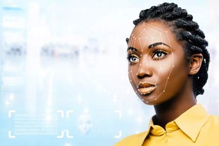 Close up portrait of attractive young african woman showing conceptual face recognition safety scan.の写真素材