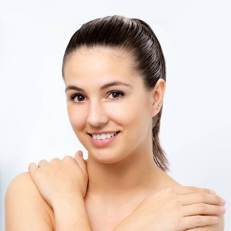 Close up beauty portrait of young attractive woman with hands on shoulders.Girl with healthy skin isolated on white background.