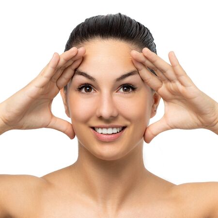 Close up beauty portrait of attractive young woman stretching facial skin with hands.Girl with hands on both sides of face. Isolated on white background.