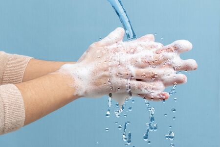 Close up detail of female hands disinfecting with soap.の写真素材
