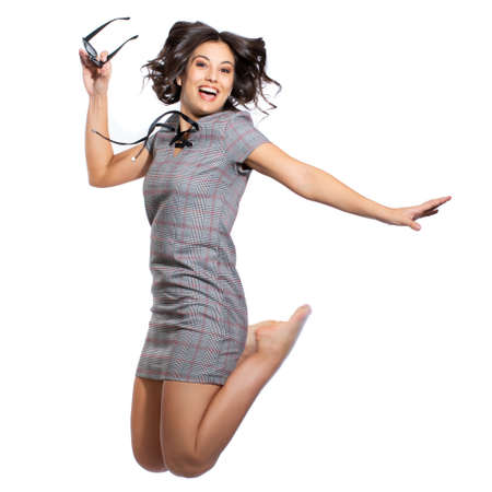 Close up studio fun portrait of attractive girl in vintage check dress. Woman holding black sunglasses jumping. Isolated on white background.の写真素材
