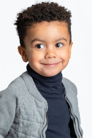 Close up studio portrait of cute afro american boy showing blank facial expression. Boy looking aside Isolated on white background.の写真素材