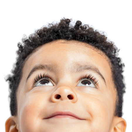 Macro close up portrait of cute little afro american boy looking up. Isolated on white background.の写真素材