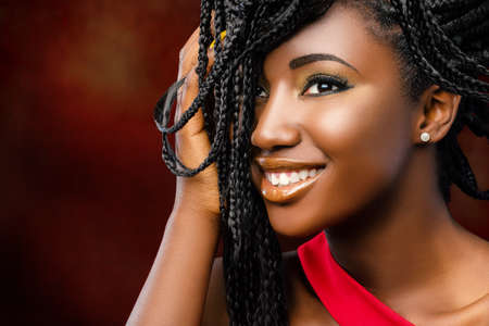 Close up beauty portrait of young attractive afro american woman with charming smile. Girl with hand...