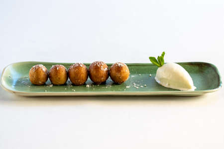 Close up dessert of appetizing round chocolate fritters with coconut ice cream.の写真素材