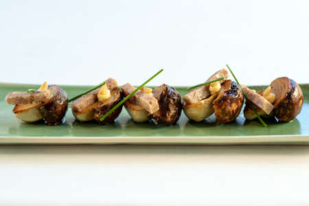 Close up front view of grilled porcini mushrooms with crisp pork strips and garlic mayonnaise.の写真素材