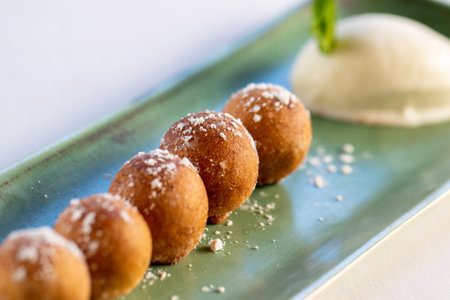 Macro close up detail of cinnamon and white chocolate fritters with vanilla ice cream.の写真素材