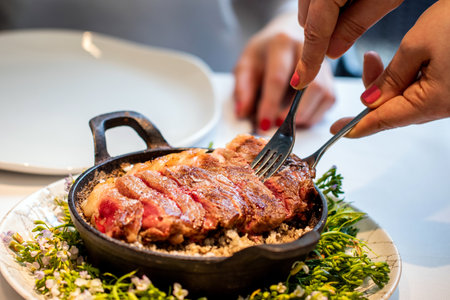 Close up of Waitress serving appetizing wagyu steak at table in restaurant.の写真素材
