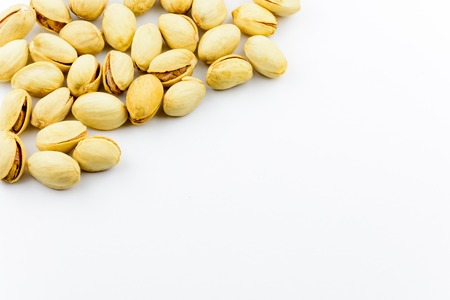 Isolated roasted  and salted pistachios nuts on a white background. Healthy natural vitamins. Source...