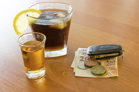 Car keys laid on the bar beside cocktail and whiskey. Whiskey and cocktail at the bar. Alcoholic...