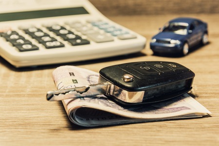 Car keys, banknotes, car model, and calculator as the concept of buying or renting a car. Loan for buying a car. Czech money at the table. Financial concept with money.の写真素材