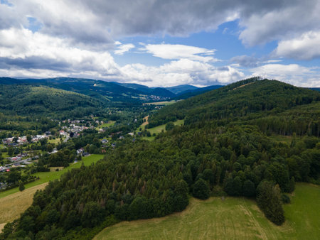 Peaks of Jeseniky with forest and small village in valley. Czechiaの写真素材