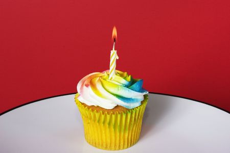Delight colored cupcake with candleの写真素材