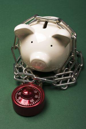 Piggy bank with a red combination lock and chainの写真素材