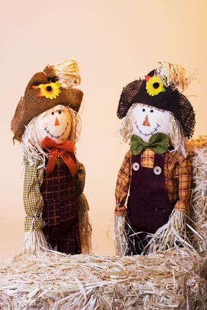 Cute boy and girl scarecrows with bales of hayの写真素材